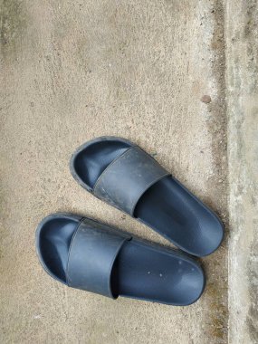 Bir çift kirli siyah terlik Tozlu bir zeminde