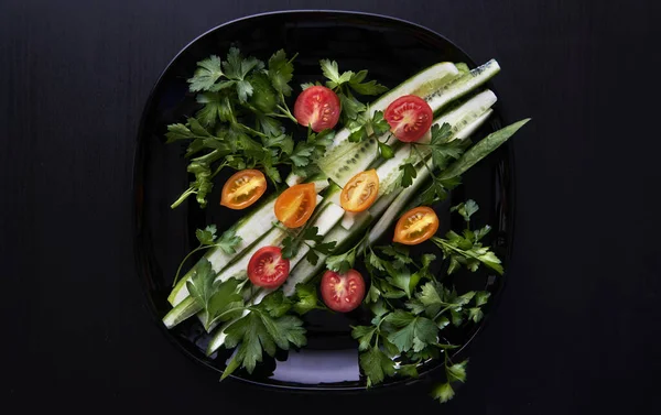 Siyah bir plaka üzerinde taze sebze salatası