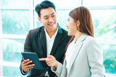 İş çifti, havaalanının kalkış alanının penceresinin yanındaki tablette bavulları ve uçuş süresini kontrol ediyor.