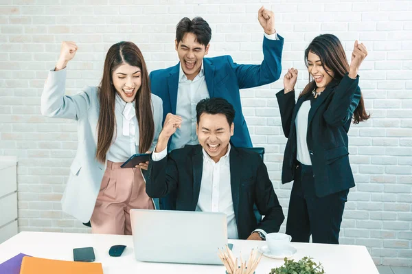 Happy diverse employees team celebrating teamwork success, business achievement at meeting.Group of successful happy business people working as a team in office on meeting.