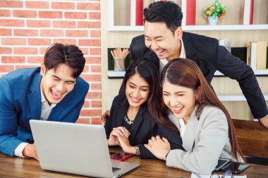 Ofisteki video konferansında genç Asyalı iş adamları ekrana bakıyor.