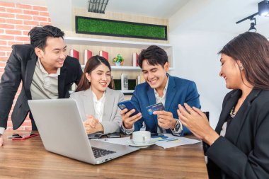 Genç Asyalı iş adamları ofiste video konferansında mobil uygulama kullanarak öğle yemeği sipariş ediyorlar.