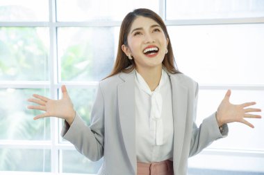 Portrait of a beauty asian business woman smiling. Portrait of a positive looking young business professional standing  on windows background.