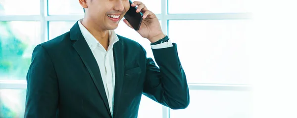 Unrecognizable  asian man using smartphone while walking at airport terminal, young asian man browsing mobile internet on cellphone while going to flight boarding, side view