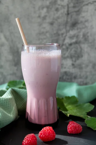 Köstlicher Himbeercocktail mit Joghurt auf dunklem Hintergrund und frischen Himbeeren daneben, Kopierraum — Stockfoto