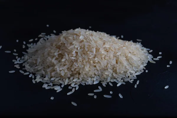 Pilha de arroz isolada sobre fundo escuro. — Fotografia de Stock