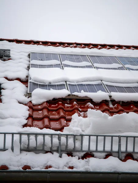 Fotovoltaico coperto di neve in inverno. La neve scivola pericolosamente dall'impianto fotovoltaico. La protezione dalla neve impedisce alla neve di cadere liberamente. — Foto Stock