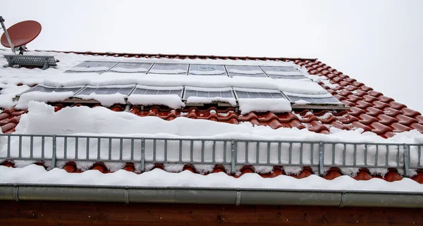 Fotovoltaika pokrytá sněhem v zimě. Z fotovoltaického systému nebezpečně padá sníh. Ochrana proti sněhu zabraňuje volnému padání sněhu. — Stock fotografie