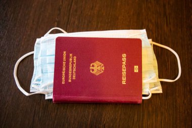 Alman pasaportu reisepass ve tıbbi yüz maskesi - Corona covid-19 pandemik konsept düz yatıyordu