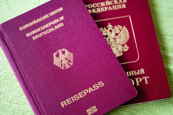 Російський Паспорт Німецьким Паспортом Ізольований Зеленому Тлі Подорожує Разом — стокове фото