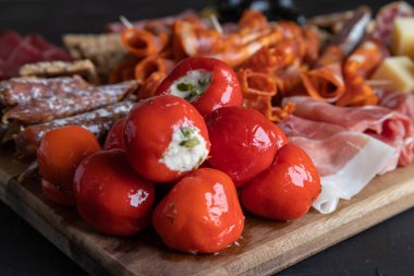 Tahtada jambon, salam, peynir, kraker ve zeytin kesme tahtası.