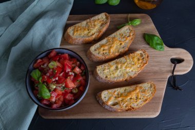 Domatesli bruschetta için rendelenmiş peynirli ciabatta dilimleri.