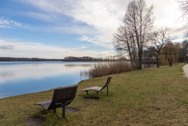 Almanya 'da Scharmuetzelsee kıyısında bir sürü kopya alanı olan bir bank. Güneşli bir günde mavi gökyüzü.