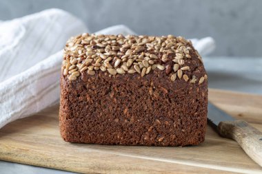 Kutu şeklinde ayçiçeği tohumlu çavdar ekmeği kesme tahtası yakın plan, sağlıklı beslenme, seçici odaklanma, kopyalama alanı