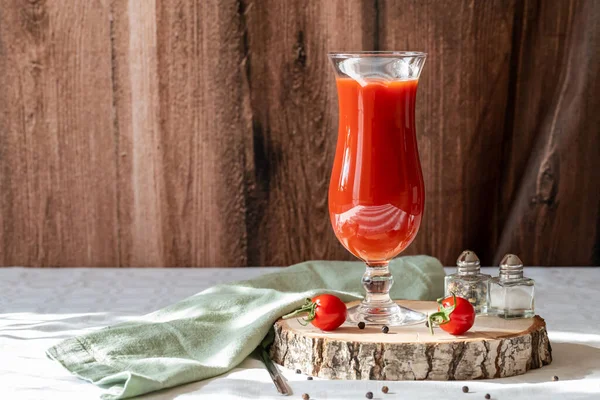 Bicchiere con succo di pomodoro, pepe, sale e pomodori su fondo di legno — Foto Stock