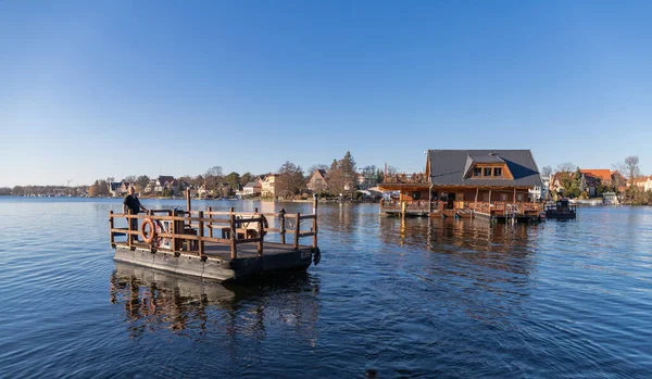 Berlin, Almanya - 13 Mart 2022, Mueggelsee, Spree Arche isimli restoranla birlikte. Ziyaretçiler restorana su botuyla götürülüyor..
