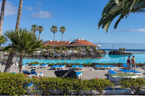 PUERTO DE LA CRUZ, TENERIFE - 9 Nisan 2022: Turistler Tenerife 'deki Puerto de la Cruz' daki Lago Martianez halk tuzlu su havuzlarında güneşin tadını çıkarıyorlar - İspanyol Kanarya Adaları 'nın en büyüğü.