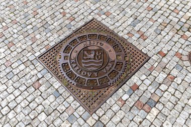 Karlovy Vary, Czech Republic - August 6, 2022, Karlovy Vary sign on an iron manhole cover in the city center, it rained recently.