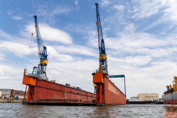 Гамбург, Германия - 25 июля 2022 года, Альстер - порт с верфями, кранами, материально-техническим обеспечением и курьерами из Гамбурга в Германии. Вид с воды, пространство для копирования.