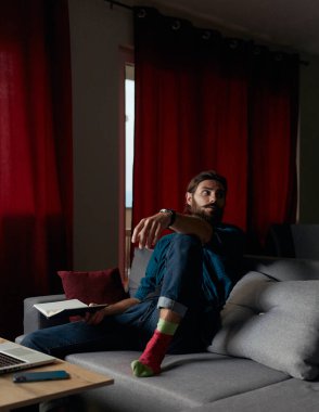 Hipster çalışan yöneticisi evdeki bir soruna çözüm düşünüyor. Elinde bir defter, dizüstü bilgisayar ve akıllı telefon vardı..