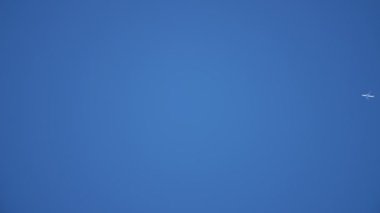 Yazın mavi gökyüzünde uçan uçaklar, güneşli bir yaz gününde iki beyaz duman şeridi bırakarak, mavi gökyüzünde hızla uçan modern bir uçağın muhteşem görüntüsünü oluşturur. İlham verici ve iyi görünüyor..