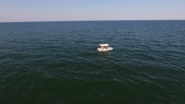 Karadeniz 'de üç kişiyle birlikte turistik salın havadan çekilmiş görüntüsü güneşli yaz günlerinde Karadeniz' in küçük dalgalarıyla açık denizde gezen sizlerle birlikte beyaz turistik bir salın iyimser kuş bakışı görüntüsü..