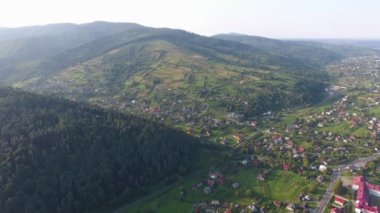 Yazın en altında şeritleri ve binaları olan bir Karpatlar sırtının havadan çekilmiş görüntüleri. Güneşli bir günde, dağların ve vadilerin uzun Karpatlar sırtı, yollar, evler, bahçeler ve çayırlarla çevrili. 