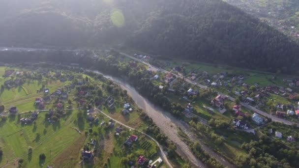 夏にカルパチアの峡谷を走る高速道路と河床の空中撮影乾燥した河床と緑の谷を車で走る現代の高速道路の鳥の目のビューを息をのむような建物 道路や夏のスプルースで覆われています — ストック動画