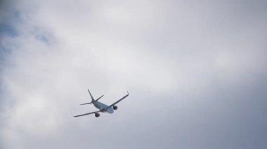 Gökyüzündeki yolcu uçağı bulutlu bir günde bulutların arka planına doğru hareket ediyor.
