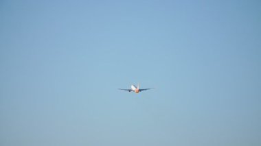 Gökyüzündeki yolcu uçağını bulutların arka planına göre hareket ettiriyor