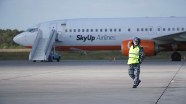 2021年11月25日 乌克兰敖德萨 一架客机停在机场附近 一名机场员工在机场附近行走 — 图库视频影像