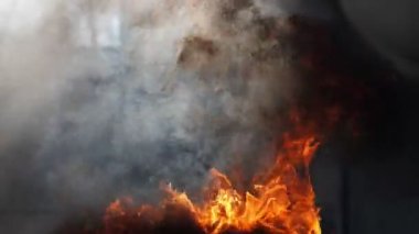 Ağır çekimde, yoğun bir ateş alevi ve zengin siyah duman. Büyüleyici görünüyor, video düzenleme için arka plan olarak kullanılabilir