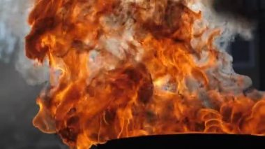 Endüstriyel konteynırların arka planında yanan petrol ürünleri olan bir fıçı, yavaş çekim