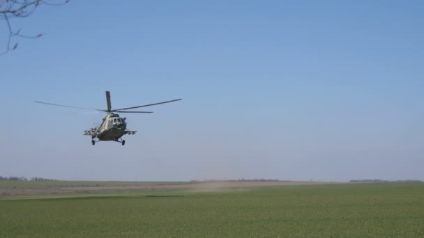 2021年10月23日 乌克兰基辅 一辆漆成土黄色的军用直升机在绿色的田野上盘旋 在蓝色的天空下翻滚 令人惊奇 — 图库视频影像