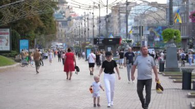 Kyiv, Ukrayna - 23 Ağustos 2022: Bir çocukla birlikte Bağımsızlık Günü 'nde Khreshhatyk' te gezinen iyimser Ukainalı aile       