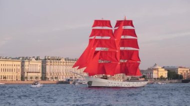 ST. PETERSBURG, RUSSIA - JUNE, 2021: The sailing ship with scarlet sails floats on the Neva. Holiday of graduates of schools. Ship with scarlet sails on the background of St. Petersburg. White night.