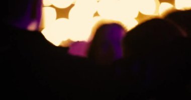 Partideki gençler sarı ve mor ışık siluetiyle dans ediyorlar. Yüksek kalite 4k görüntü