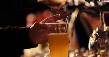 Bartender pours beer into a plastic glass and gives it to the client at the party. High quality 4k footage
