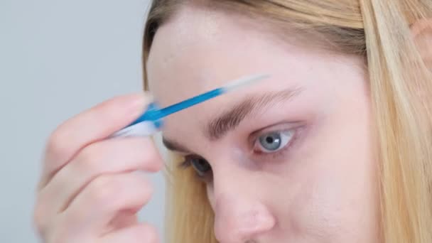Young Blonde Woman Combing Her Eyebrows Studio White Background High — Wideo stockowe