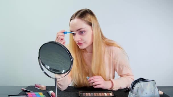 Young Blonde Woman Combing Her Eyebrows Doing Make Studio White — Stockvideo