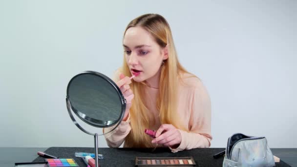 Young Blonde Woman Paints Her Lips Gloss Doing Makeup Studio — Stockvideo