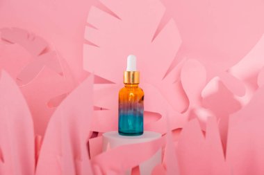 Beyaz bir podyumda üzerinde pipeti olan damlatan cam şişeler. Şeffaf hyaluronik doğal güzellik mineral ürünü ve eko serumu cilt bakımı kavramı.