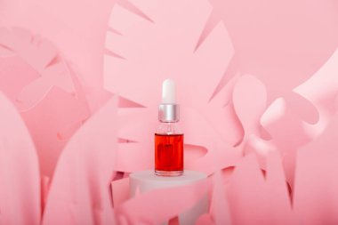 Beyaz bir podyumda üzerinde pipeti olan damlatan cam şişeler. Şeffaf hyaluronik doğal güzellik mineral ürünü ve eko serumu cilt bakımı kavramı.