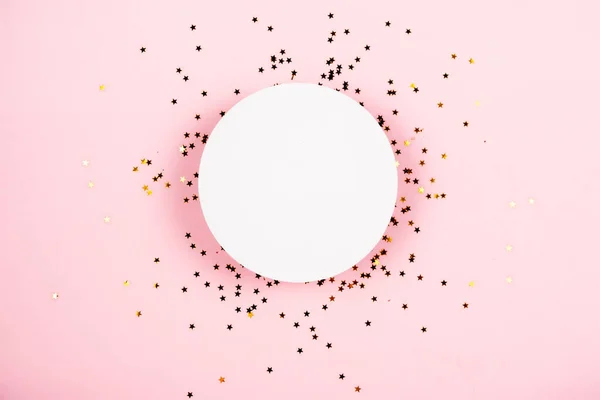 Gouden sterren schitteren confetti onder wit podium voor cosmetica vitrine op roze pastel trendy achtergrond. — Stockfoto