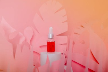 Beyaz bir podyumda üzerinde pipeti olan damlatan cam şişeler. Şeffaf hyaluronik doğal güzellik mineral ürünü ve eko serumu cilt bakımı kavramı