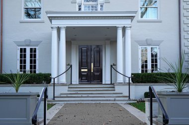 İki katlı, tuğlalı, zarif giriş kapısı olan bir ev.