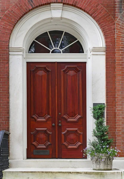 Elegant mahogany wood double door, entrance to an old townhouse or apartment building.