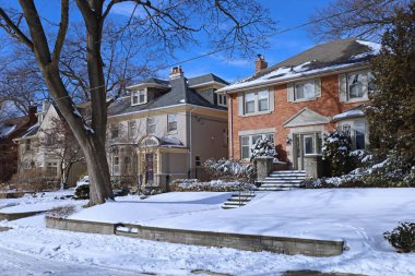 Kışın güneşli bir günde geleneksel orta sınıf bekar aile evleri sokağı.