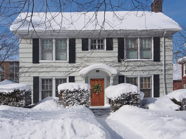 İki katlı orta sınıf ev karla kaplı.