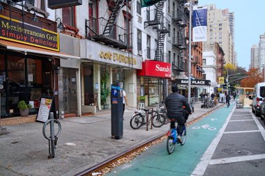 New York, NY- 17 Kasım 2021: Bisiklet, birinci cadde gibi ana caddelerde birbirinden ayrı bisiklet yollarıyla popüler bir ulaşım aracı haline geldi..